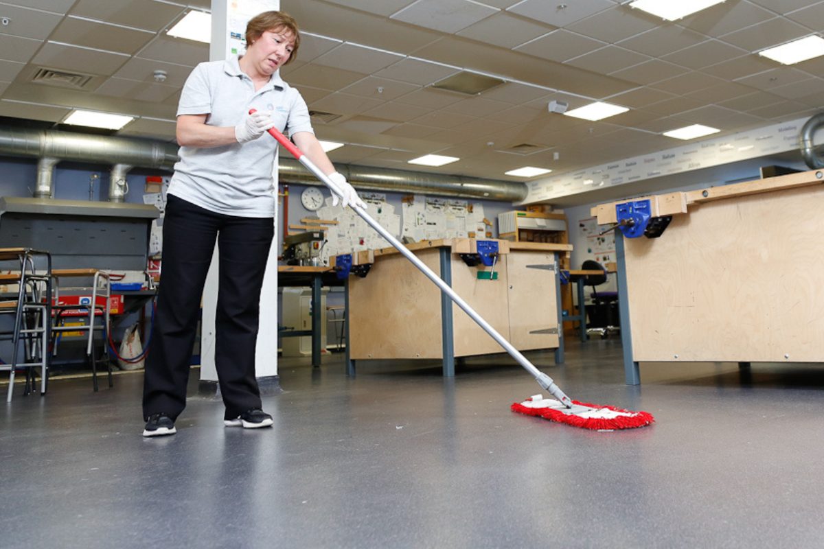 woman sweeping in a classroom